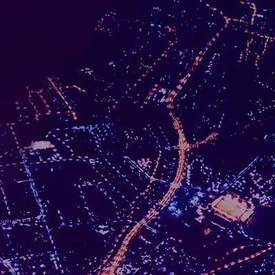 Beleuchtete Straßen einer Stadt in der Nacht aus der Vogelperspektive