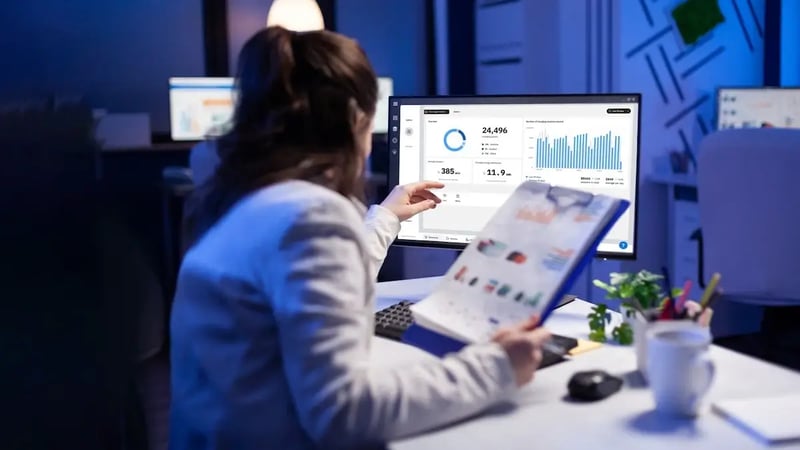 Foto på en kvinna som tittar på en datorskärm som visar en dashboard för Virtas Adminpanel