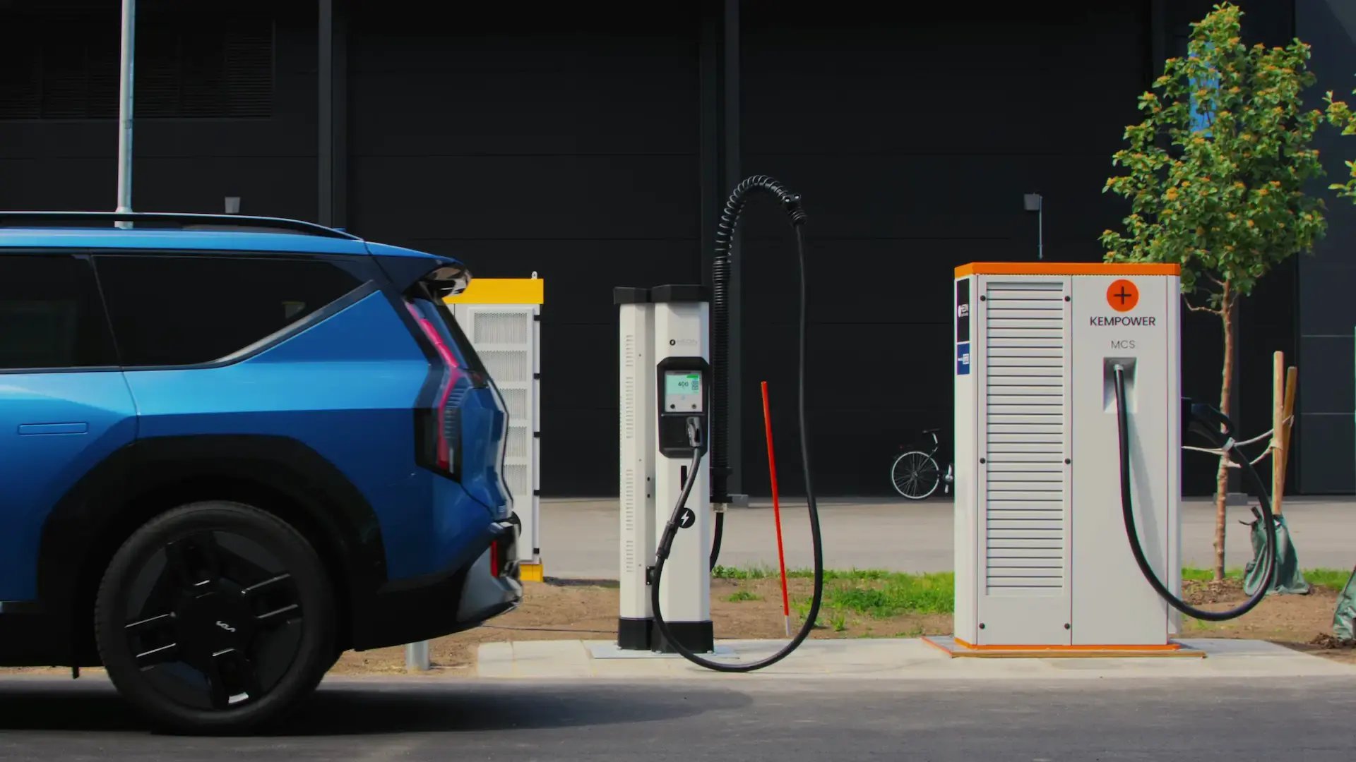 Blue SUV EV in front of Hedin Supercharger Kempower MCS