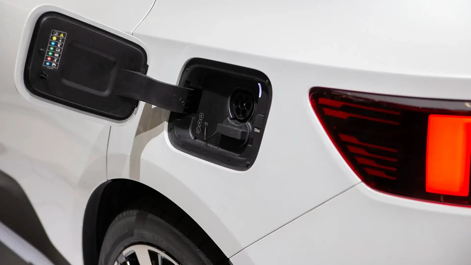 Detailansicht eines weißes E-Autos von der Seite mit offener Ladebuchse zum Laden