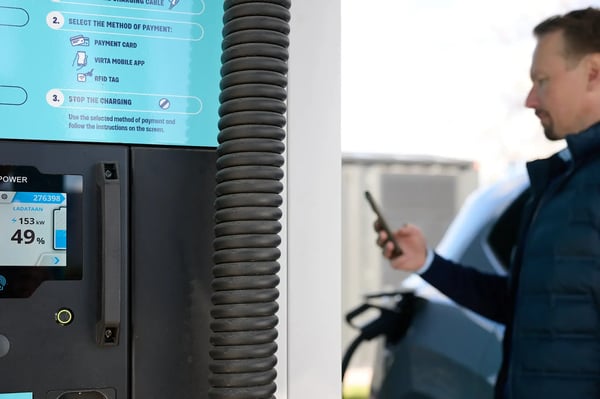 A man charging an EV at Faast Helsinki airport charging station with the guaranteed 150kW power