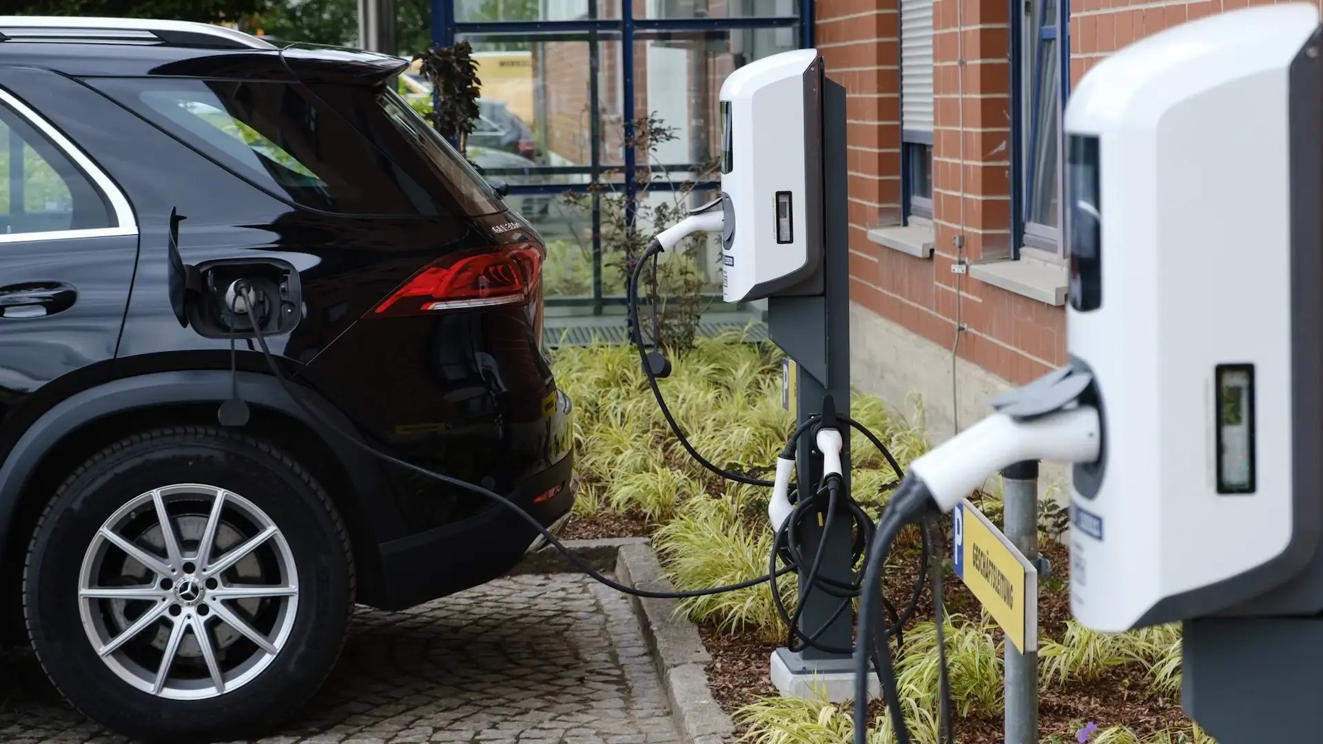 Black hybrid EV charging at one of two alfen double charging stations in front of gp papenburg ag office building