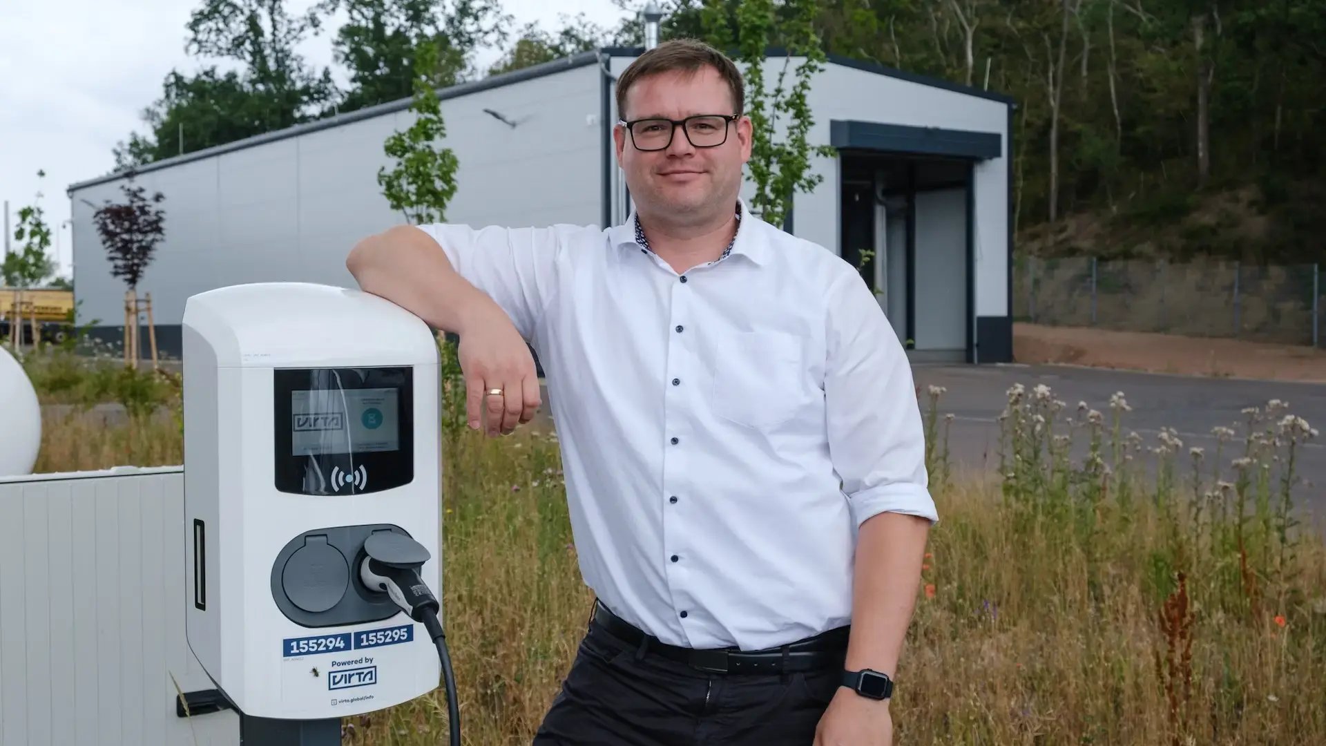 Felix Windrich Energy Managemet at GP Papenburg AG next to Virta double charging station at office parking lot