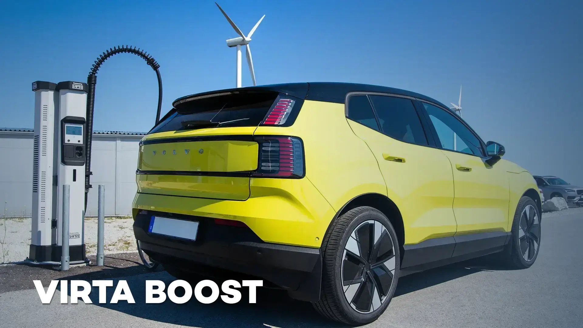 Virta Boost main image showing yellow EV charging at Kempower Satellite charging station with wind turbines renewable energy production in the background