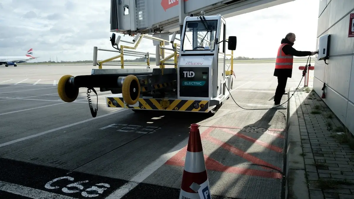 Foto på ett lastfordon för flygplan som laddas med hjälp av en Virta Double-laddstation på Berlin Brandenburgs flygplats