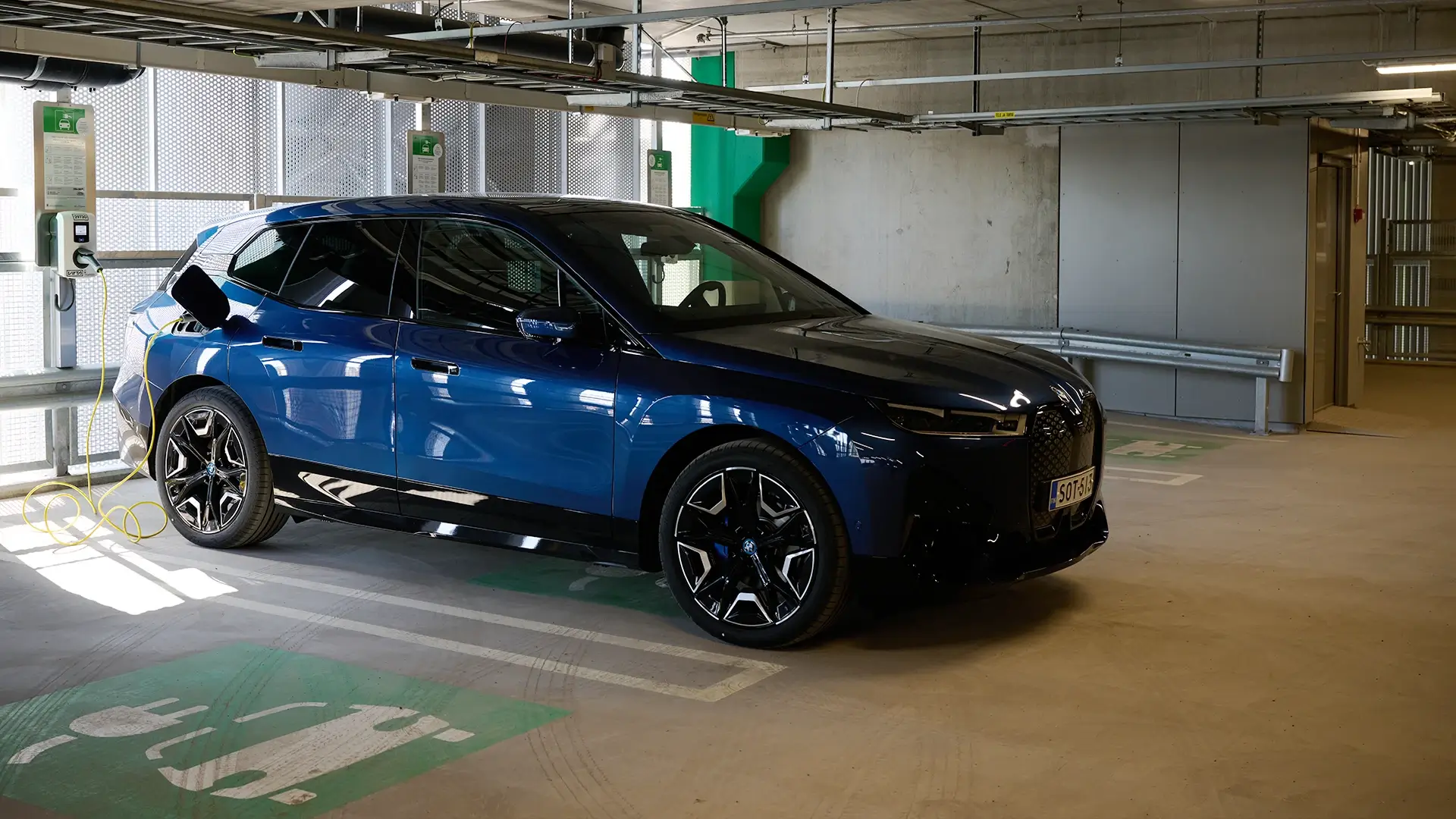 voiture bleue connectée à une borne dans un parking 