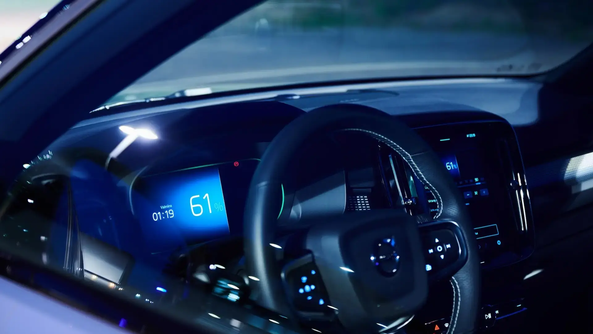 Innenansicht beleuchtetes Amaturenbrett eines E-Autos mit dunklem Hintergrund