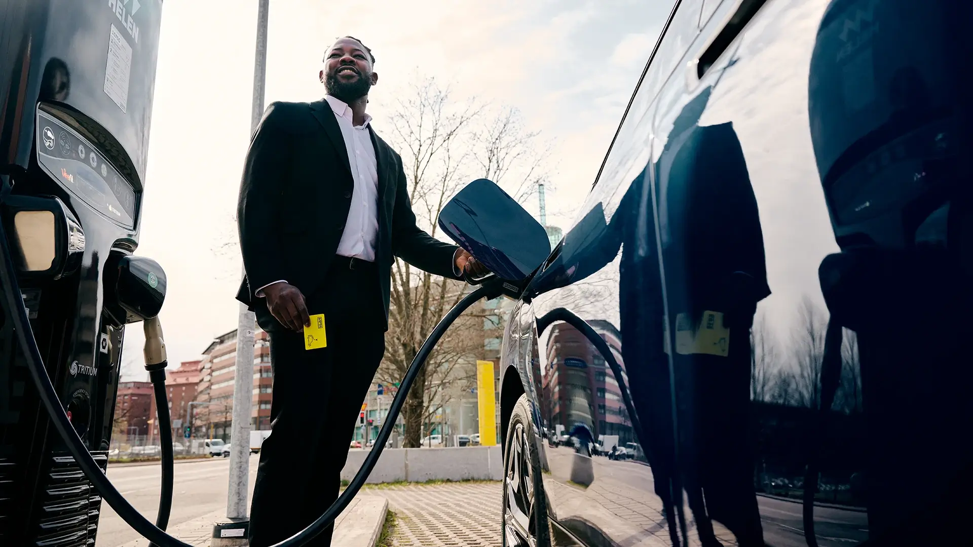 Businessman charging electric car city