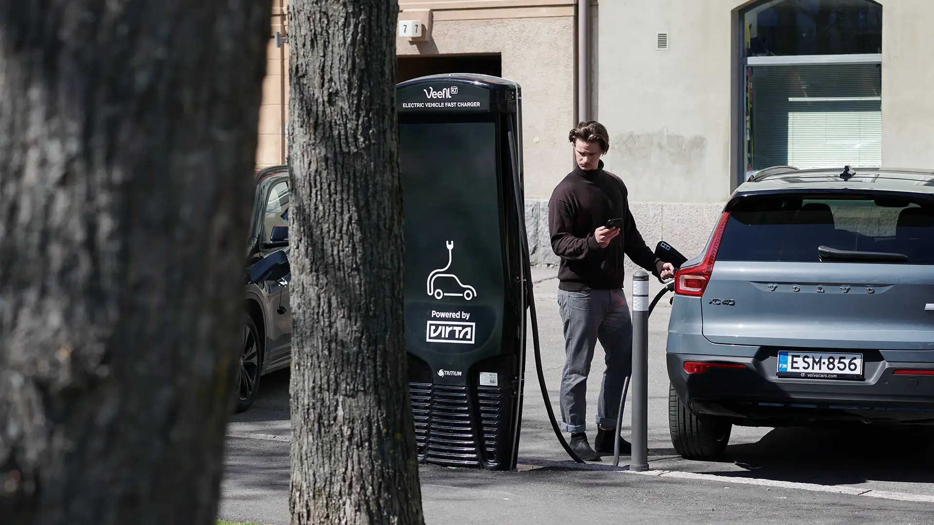 Man using Virta EV fast charger on street
