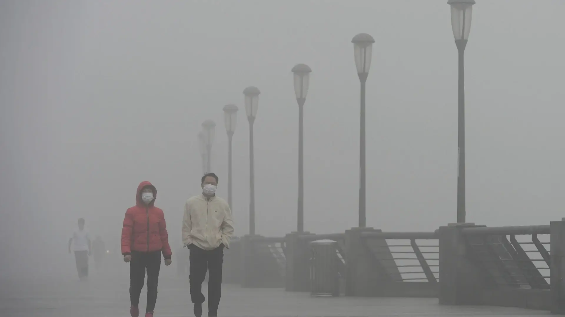Två män går över en bro förorenad luft smog