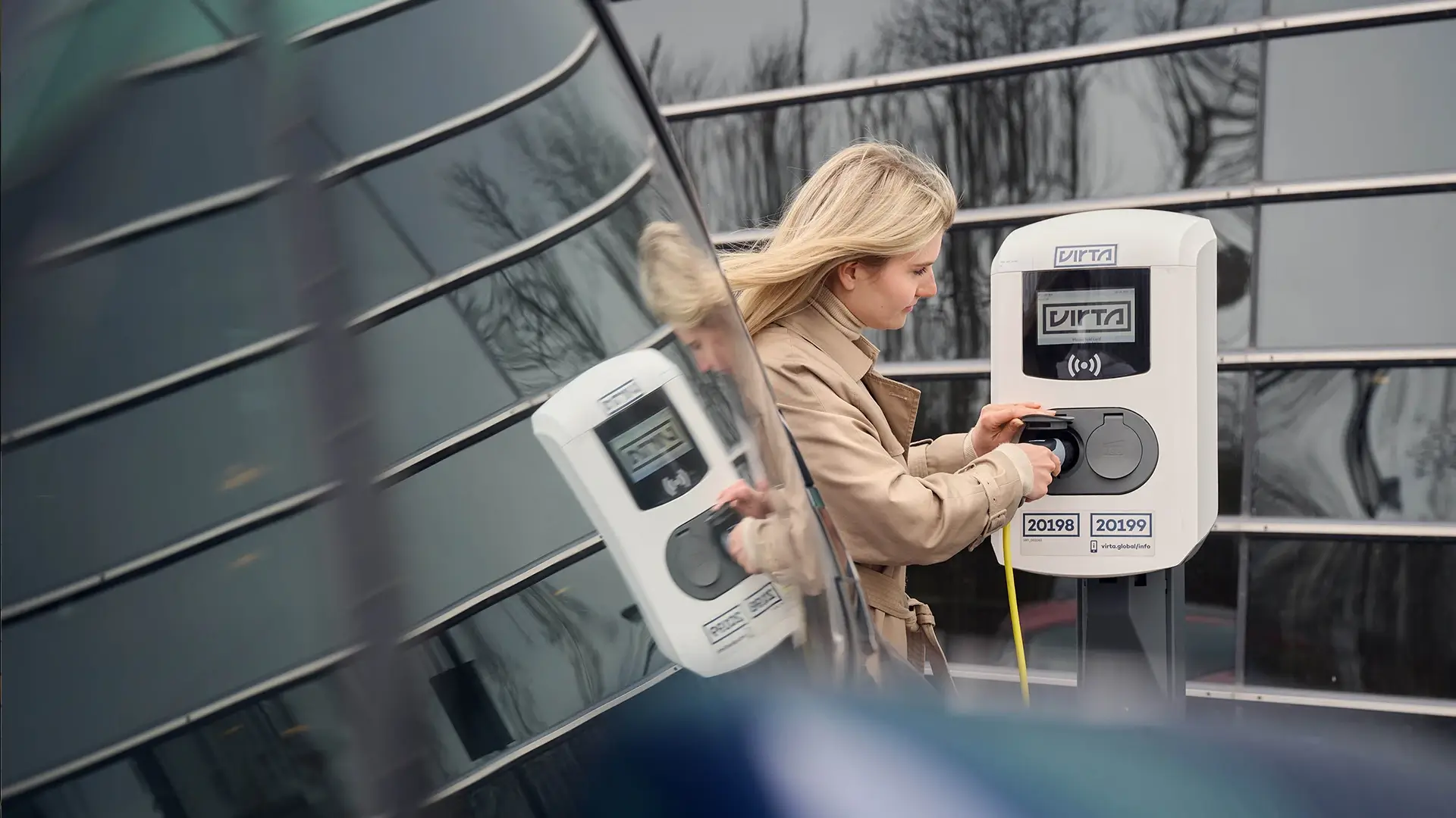 Woman operating Virta EV AC charging station