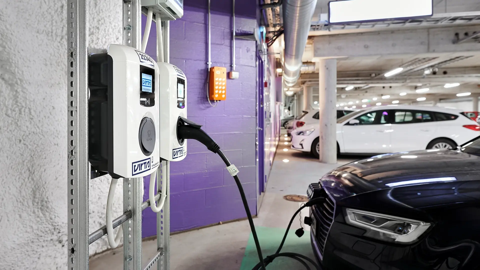 Rokkiparkki Finnland E-Auto hängt an AC Ladestation in Parkgarage